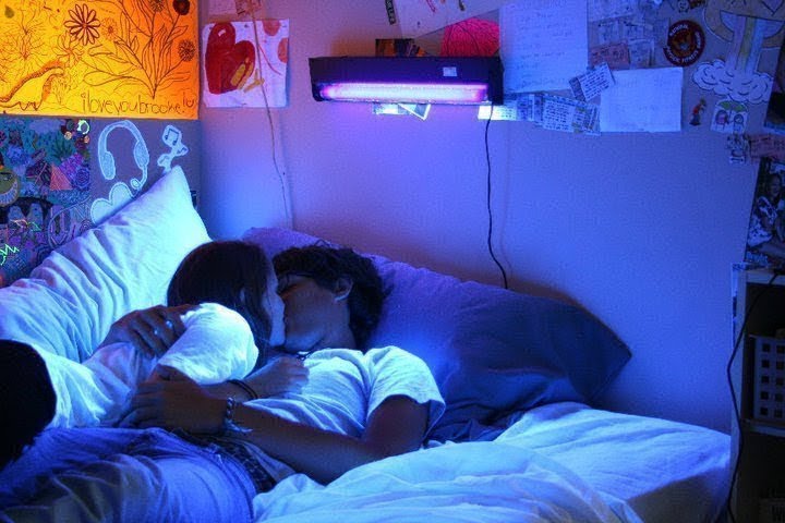 Молодая пара лежат и целуются в кровати